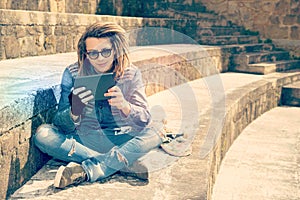 Handsome guy with dreadlocks readng a tablet warm filter applied