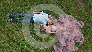Handsome guy with girlfriend lying on the field and dreaming.