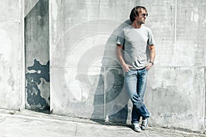 Handsome guy in gray t-shirt over street wall