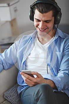 Handsome guy listening to music on internet with smartphone
