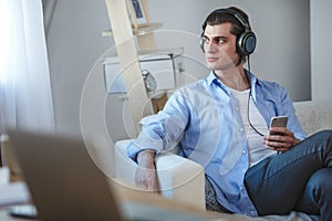 Handsome guy listening to music on internet with smartphone