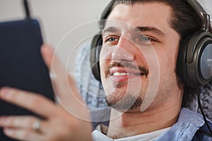 Handsome guy listening to music on internet with tablet