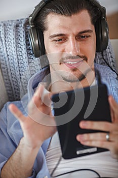 Handsome guy listening to music on internet with tablet