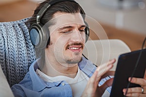 Handsome guy listening to music on internet with tablet
