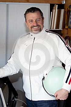 handsome guy portrait of happy middle aged caucasian man car race white jacket and retro racing helmet