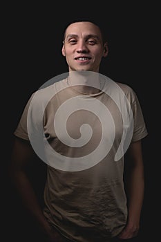 Handsome guy posing in studio on isolated black background. Studio portrait with one light source