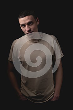 Handsome guy posing in studio on isolated black background. Studio portrait with one light source