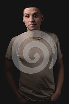 Handsome guy posing in studio on isolated black background. Studio portrait with one light source