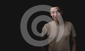 Handsome guy posing in studio on isolated black background. Studio portrait with one light source