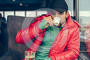 Handsome guy relaxing and drinking coffee on a cold day