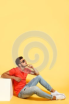 Handsome guy sitting on floor looking up