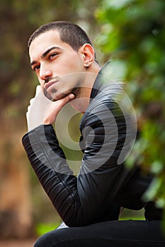 Handsome guy sitting thinking. Short hair