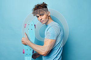 handsome guy skateboard in hand in blue t-shirts Lifestyle unaltered