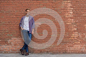 Handsome guy standing near brick wall