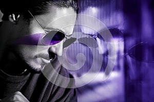 Handsome guy in sunglasses with reflection. Fashionable ultraviolet artistic image. Composite image with black and white.