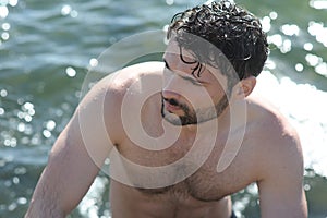 Handsome guy topless portrait in sea