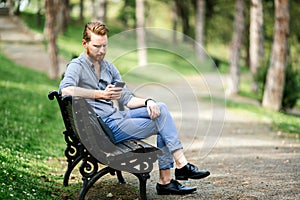 Handsome guy using phone in park