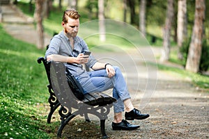 Handsome guy using phone in park