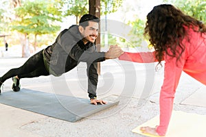 Handsome guy working out with a young woman in the park