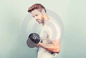 Handsome guy workout. Exercising at gym. Muscular man exercising with dumbbell. Sportsman training strong muscles. Sport