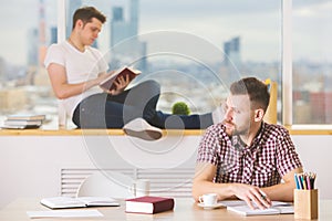 Handsome guys reading book and doing paperwork