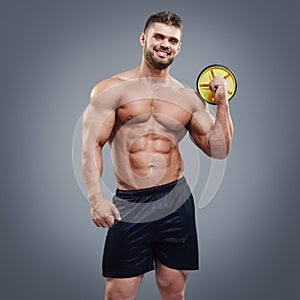 Handsome gym trainer guy on grey background