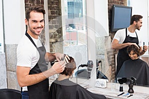 Handsome hair stylist with client