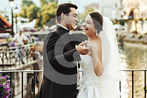 Handsome happy bride and beautiful sensual groom at romantic bridge in france closeup