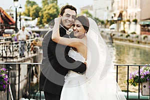 Handsome happy bride and beautiful sensual groom at romantic bridge in france closeup