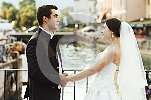 Handsome happy bride and beautiful sensual groom at romantic bridge in france closeup