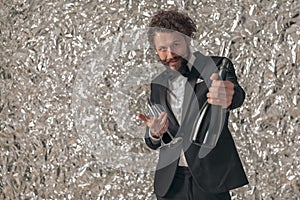 Handsome happy man in elegant tuxedo recommending champagne bottle photo