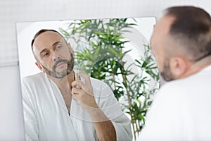 handsome happy man perfuming himself