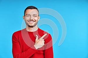 Handsome happy man pointing his finger showing empty copy space