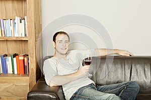 Handsome happy man relaxing with a glass of wine