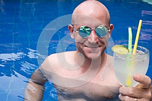 Man with cocktail in the pool