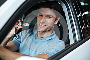 Handsome happy man sitting in his new car