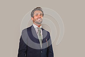 Handsome happy man in suit posing for company corporate business portrait relaxed and confident smiling happy isolated on grey as