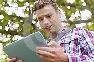 Handsome happy student using tablet