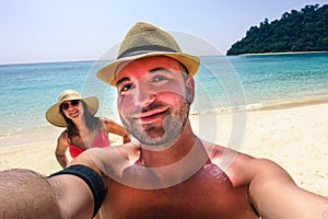 Handsome hipster couple making selfie on paradise beach