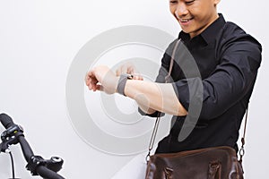 Handsome hipster enjoying a bike ride and checking time on his watch