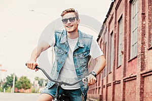 Handsome hipster enjoying city ride by bicycle.