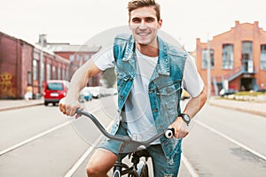 Handsome hipster enjoying city ride by bicycle.