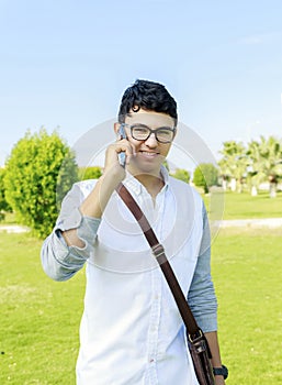 Handsome hipster modern man outdoors and talking on mobile phone.