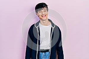 Handsome hipster young man wearing casual white t shirt and sweatshirt with a happy and cool smile on face