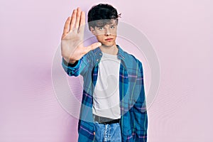 Handsome hipster young man wearing casual white t shirt and vintage shirt doing stop sing with palm of the hand