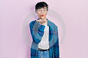 Handsome hipster young man wearing casual white t shirt and vintage shirt looking at the camera blowing a kiss with hand on air