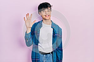 Handsome hipster young man wearing casual white t shirt and vintage shirt showing and pointing up with fingers number five while