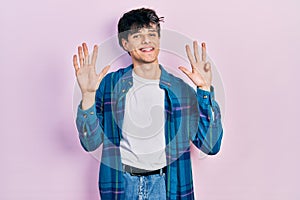 Handsome hipster young man wearing casual white t shirt and vintage shirt showing and pointing up with fingers number nine while