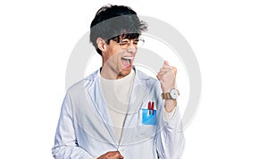 Handsome hipster young man wearing doctor uniform celebrating surprised and amazed for success with arms raised and eyes closed