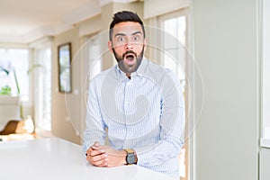 Handsome hispanic business man afraid and shocked with surprise expression, fear and excited face